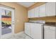 Bright laundry room with white cabinets, machines, and access to outside at 7849 Georgeann St, Winter Park, FL 32792