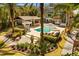 Lush tropical backyard featuring a sparkling pool, spa, and covered outdoor kitchen at 7849 Georgeann St, Winter Park, FL 32792