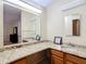 Granite counters complement dual sinks and wood cabinets in this Primary bathroom at 840 Cortez Ave, The Villages, FL 32159
