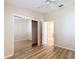 Bright, empty bedroom features a ceiling fan, wood floors, and mirrored closet at 840 Cortez Ave, The Villages, FL 32159
