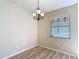 Cozy dining area with decorative chandelier and a window providing natural light, complemented by wood-look flooring at 840 Cortez Ave, The Villages, FL 32159