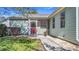 Charming home with a red door, screened front porch, well-maintained lawn, and pretty landscaping at 840 Cortez Ave, The Villages, FL 32159