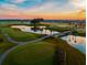 Stunning aerial view of the meticulously landscaped golf course at sunset with water features at 840 Cortez Ave, The Villages, FL 32159