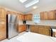 Spacious kitchen with wooden cabinets, stainless steel refrigerator, and white countertops at 840 Cortez Ave, The Villages, FL 32159