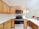 Kitchen area featuring wooden cabinets, stainless steel appliances, and white countertops at 840 Cortez Ave, The Villages, FL 32159