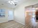 Open-concept living area with wood-look flooring and access to the kitchen, perfect for modern living and entertaining at 840 Cortez Ave, The Villages, FL 32159