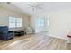 Inviting living room featuring wood-look flooring, vaulted ceilings, and an abundance of natural light from multiple windows at 840 Cortez Ave, The Villages, FL 32159