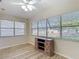 Bright sunroom featuring wood-look floors and large windows offering natural light and views of the outdoors at 840 Cortez Ave, The Villages, FL 32159