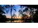 Beautiful lake view at sunset framed by palm trees and lush foliage, creating a serene tropical atmosphere at 858 Lake Marion Dr, Altamonte Springs, FL 32701
