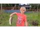 A young boy proudly displays a freshly caught fish in front of a charming lake house at 858 Lake Marion Dr, Altamonte Springs, FL 32701