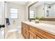 Bathroom featuring a wood vanity cabinet, stone countertop, framed mirror and tiled shower at 1011 Terry Dr, Altamonte Springs, FL 32714