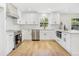 Modern kitchen with white cabinets, stainless steel appliances, a window and wood flooring at 1011 Terry Dr, Altamonte Springs, FL 32714