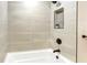 Close-up of shower featuring tiled walls, black fixtures, and built-in toiletry niche at 1011 Terry Dr, Altamonte Springs, FL 32714
