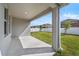 This covered porch offers views of the grass backyard and a white picket fence at 10151 Salt Point Dr, Winter Garden, FL 34787