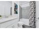 Bathroom with quartz countertop, grey tile accent, and a tub with shower at 10151 Salt Point Dr, Winter Garden, FL 34787