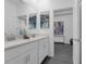 Elegant bathroom featuring double vanity with white cabinets, gray floors and modern decor at 10151 Salt Point Dr, Winter Garden, FL 34787