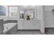 This bathroom features a double vanity sink, a soaking tub, and gray tile at 10151 Salt Point Dr, Winter Garden, FL 34787