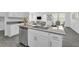 Modern kitchen with gray countertops, stainless steel dishwasher, and views to living room at 10151 Salt Point Dr, Winter Garden, FL 34787