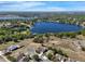 Expansive aerial view of lakefront homes nestled among lush trees with blue skies and sparkling water at 1028 Marietta Ln, Eustis, FL 32726