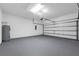 Spacious two-car garage featuring durable painted floors, cinder block walls, and automatic door at 1028 Marietta Ln, Eustis, FL 32726
