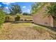 Fenced backyard with mature trees, lawn and landscaped hillside at 1037 Sailing Bay Dr, Clermont, FL 34711