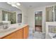 Bathroom featuring dual sinks, granite counters, and tiled shower at 1037 Sailing Bay Dr, Clermont, FL 34711