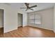 Bright bedroom with wood floors features a ceiling fan and closet for storage at 1037 Sailing Bay Dr, Clermont, FL 34711