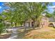Two-story home with stucco exterior, mature trees, and driveway at 1037 Sailing Bay Dr, Clermont, FL 34711