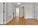 Hallway with wood floors, neutral paint, and access to multiple rooms in the home at 1037 Sailing Bay Dr, Clermont, FL 34711