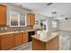 Open concept kitchen with island, wood cabinets, tiled backsplash, and views to backyard at 1037 Sailing Bay Dr, Clermont, FL 34711