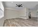 Bright living room with light-colored walls, wood floors, a ceiling fan, and large windows at 1037 Sailing Bay Dr, Clermont, FL 34711