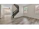 Open-concept living room with wood-look floors and staircase at 1037 Sailing Bay Dr, Clermont, FL 34711
