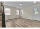 Bright living room featuring wood-look floors and multiple windows at 1037 Sailing Bay Dr, Clermont, FL 34711
