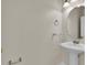 Small powder room with white pedestal sink and oval mirror at 1037 Sailing Bay Dr, Clermont, FL 34711