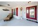 Inviting front porch with seating area, welcome sign, red door and shutters with glass features at 104 Bentley Oaks Blvd, Auburndale, FL 33823
