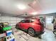 Spacious garage featuring a late model red SUV parked in front of an automatic door at 104 Bentley Oaks Blvd, Auburndale, FL 33823