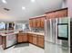 Kitchen with stainless steel refrigerator and matching appliances plus wood cabinets at 104 Bentley Oaks Blvd, Auburndale, FL 33823