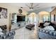 Modern living room featuring tile flooring, statement ceiling fan, and mirrored shelving units at 104 Bentley Oaks Blvd, Auburndale, FL 33823