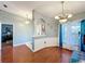Living room boasts a half wall divider, elegant lighting, hardwood flooring and a doorway at 104 Bentley Oaks Blvd, Auburndale, FL 33823