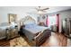 Lavish main bedroom featuring a large bed with tufted headboard, hardwood floors, and windows for natural light at 104 Bentley Oaks Blvd, Auburndale, FL 33823