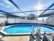 Sparkling in-ground pool surrounded by screened enclosure and concrete patio for outdoor enjoyment at 104 Bentley Oaks Blvd, Auburndale, FL 33823