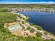 Breathtaking aerial view of a lakeside community featuring lush trees, a playground, and tennis courts for active living at 10852 Spider Lily Dr # S, Orlando, FL 32832