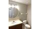 Modern bathroom with a round mirror, a well-lit vanity, and a convenient toilet at 10852 Spider Lily Dr # S, Orlando, FL 32832