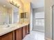 Bathroom with double sink vanity, tiled floor, and a walk-in shower at 10852 Spider Lily Dr # S, Orlando, FL 32832