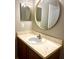 Bathroom featuring a modern round mirror, stylish vanity, and ample lighting at 10852 Spider Lily Dr # S, Orlando, FL 32832