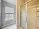 Bright bathroom featuring a glass-enclosed shower, tiled floors, and a window providing natural light at 10852 Spider Lily Dr # S, Orlando, FL 32832