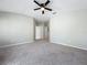 Spacious carpeted bedroom with a ceiling fan and two hallway doors at 10852 Spider Lily Dr # S, Orlando, FL 32832