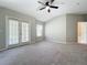 Spacious bedroom featuring plush carpet, a ceiling fan, and sliding glass doors to a balcony at 10852 Spider Lily Dr # S, Orlando, FL 32832