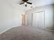 Spacious bedroom with neutral walls, plush carpeting, a ceiling fan, and a double door closet at 10852 Spider Lily Dr # S, Orlando, FL 32832