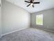 A bright bedroom with carpet, neutral walls, a ceiling fan, and a window providing natural light at 10852 Spider Lily Dr # S, Orlando, FL 32832